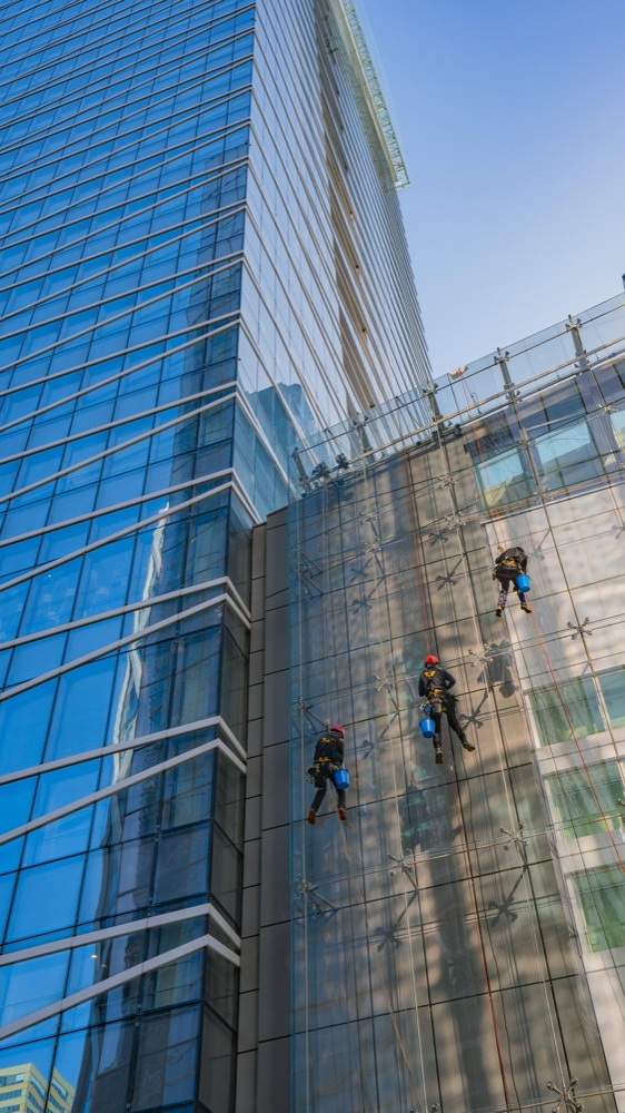 Workers in safety harnesses at height