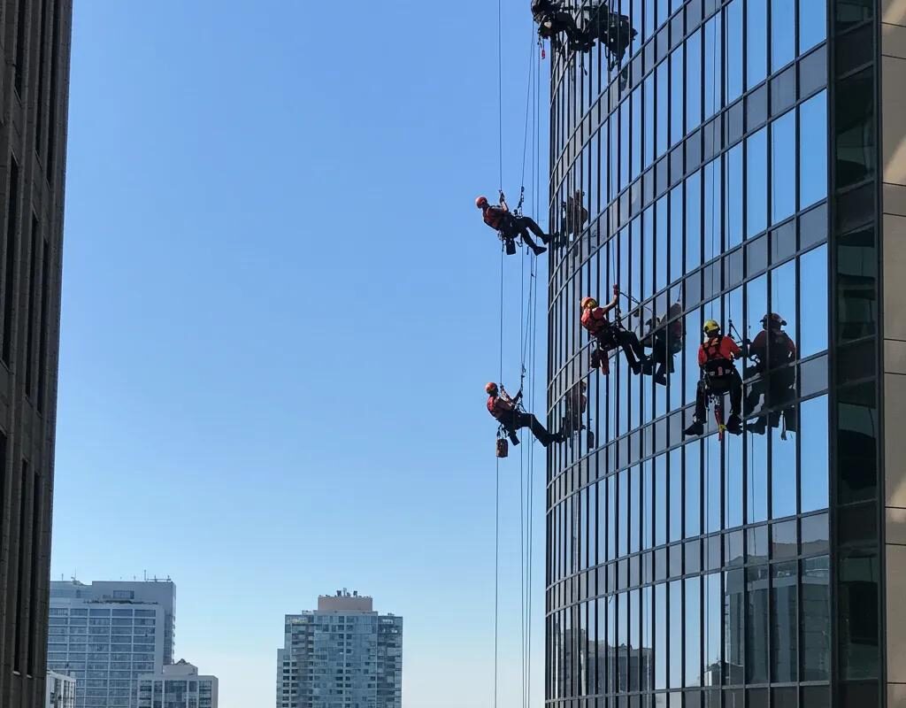 Workers in safety harnesses on high-rise